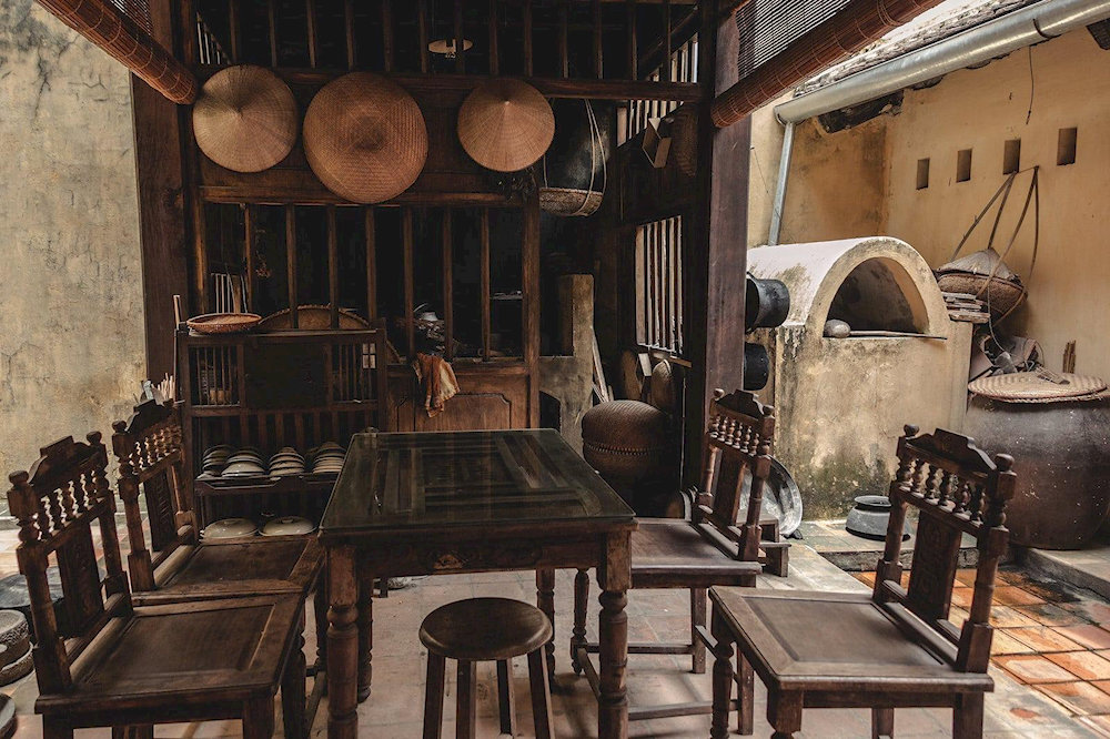 The house features a charming wooden structure with an open courtyard and antique furniture